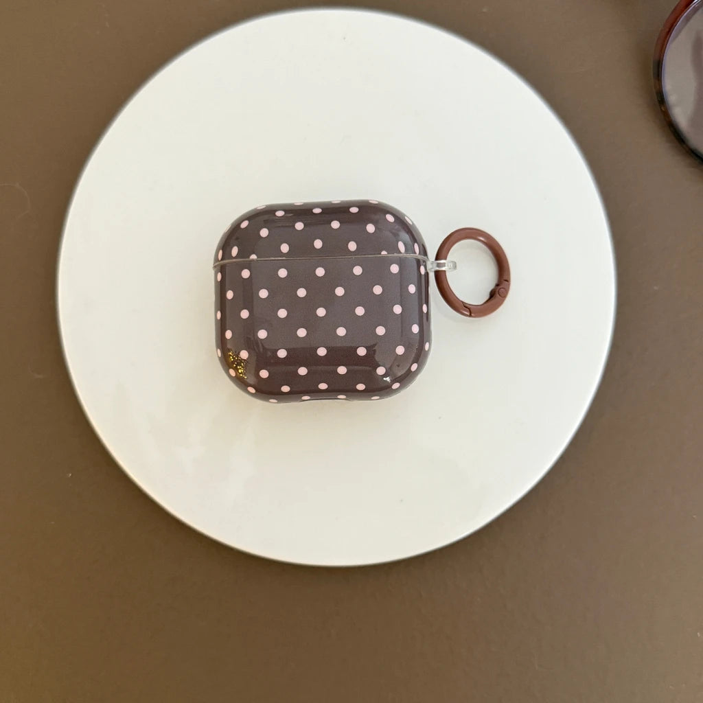 Brown glossy AirPods case with pink polka dots and matching ring clip. Compatible with AirPods.