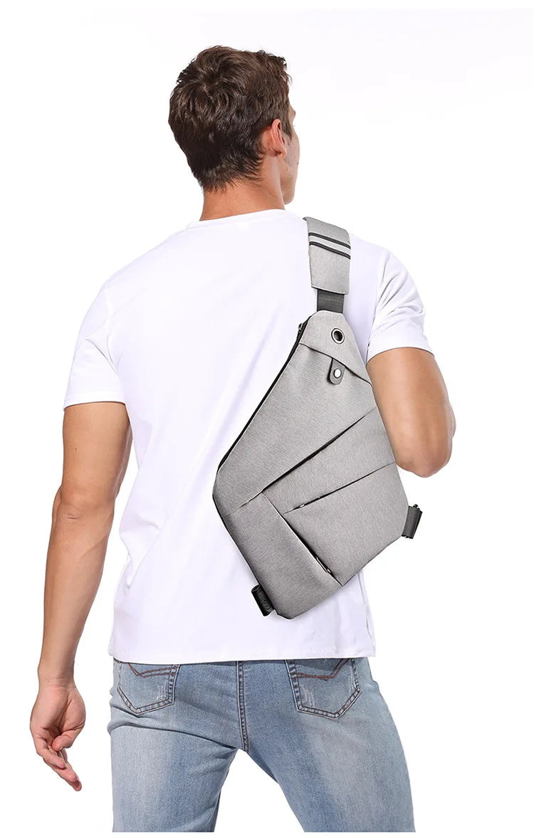 Man wearing a slim, grey waterproof crossbody bag with a sleek, minimalist design over a white t-shirt.