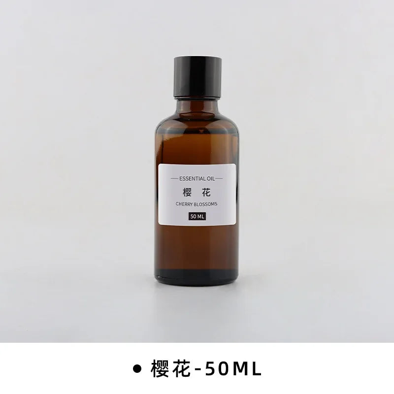 50ml amber glass bottle of Cherry Blossom essential oil with a black screw-top lid and minimalist white label.