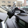 Black car dashboard phone mount with adjustable swivel arm and suction cup base, holding a smartphone in profile.