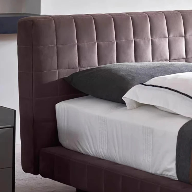Modern Nordic bed frame in dark aubergine velvet with a plush, square-quilted headboard and low-profile design.