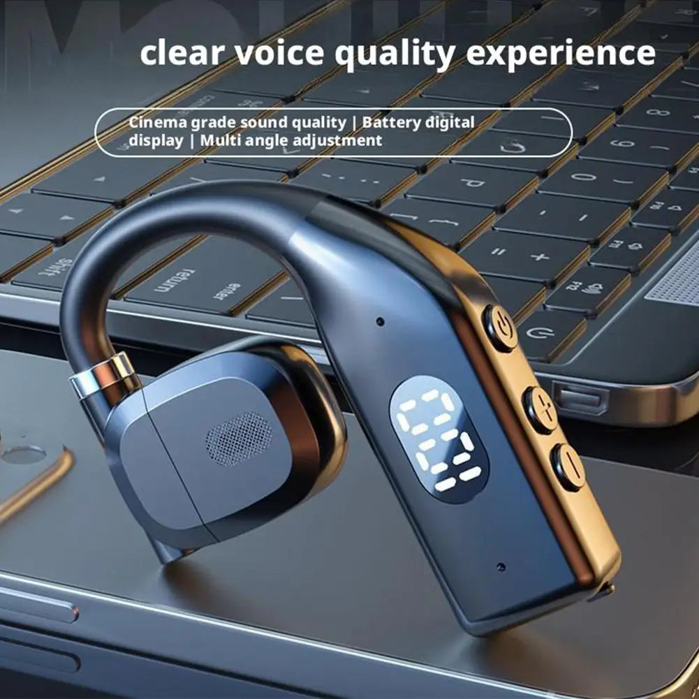 Black wireless ear hook headset with a digital LED battery display and side control buttons, resting on a laptop.