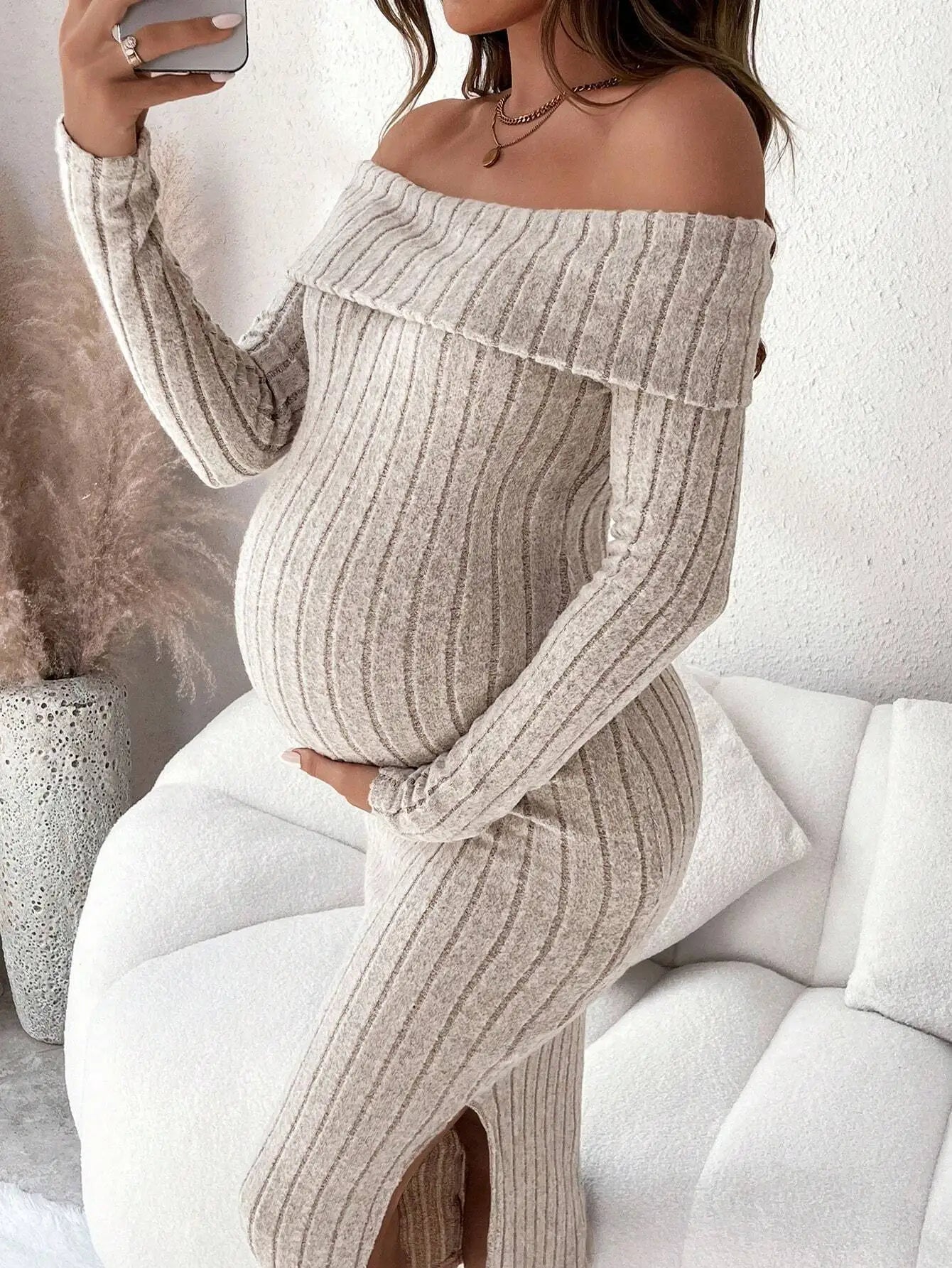 Beige off-the-shoulder maternity ribbed knit dress with long sleeves and a side slit.