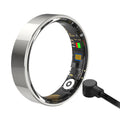 A sleek, polished silver smart health ring showing internal sensors and a magnetic charging cable.
