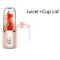 Portable pink personal blender with a clear cup containing tomato juice and a matching pink travel lid.