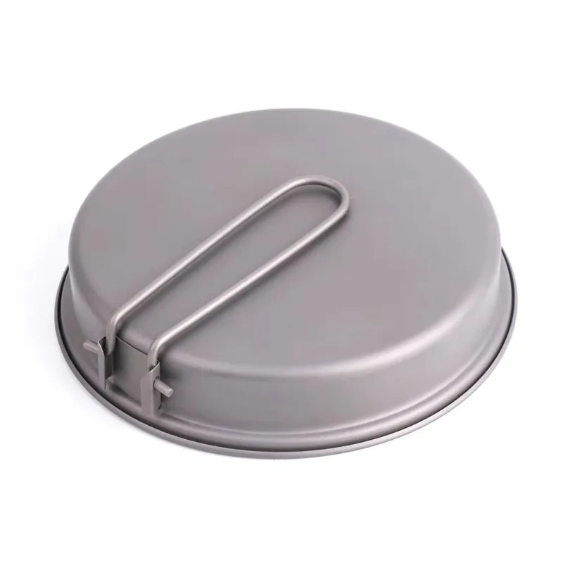 Grey titanium camping pan with a folding handle on the bottom, viewed from an angle on a white background.