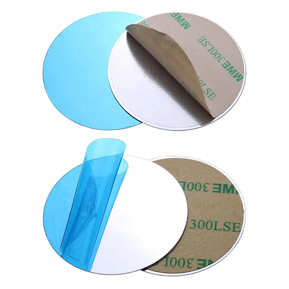 Two silver circular adhesive stickers, each with blue protective film on one side and a paper backing on the other.