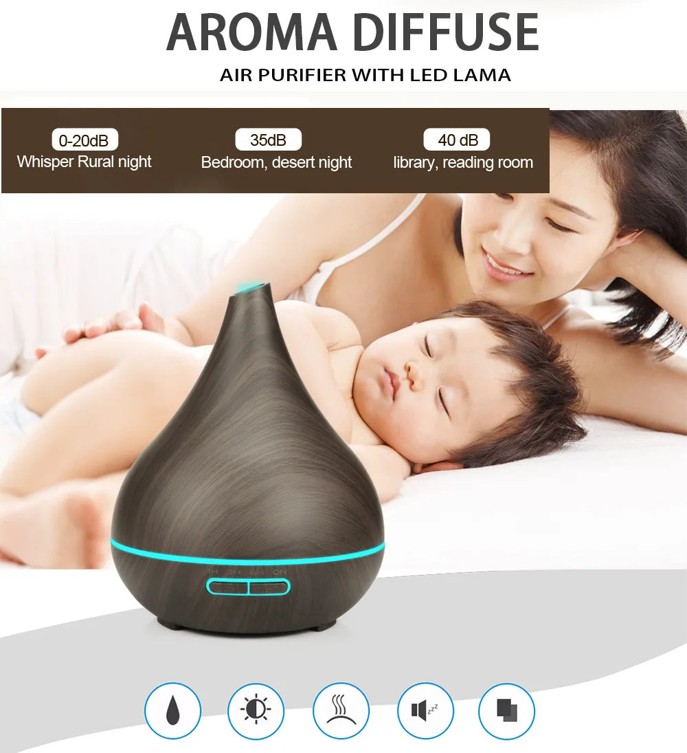 Dark wood grain teardrop-shaped essential oil diffuser with glowing blue LED light, set against a calm bedroom scene.