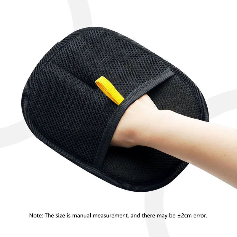 Black mesh wash mitt with a yellow hanging loop, worn on a hand against a white background.