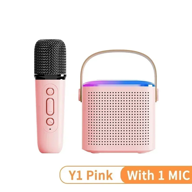 Pink portable Bluetooth speaker with RGB lighting, carrying handle, and matching wireless microphone.