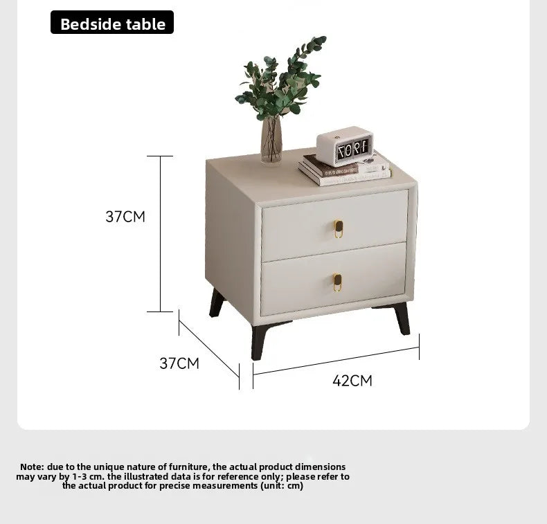 Modern cream-white bedside table with two drawers, gold handles, dark legs, and dimensions shown.