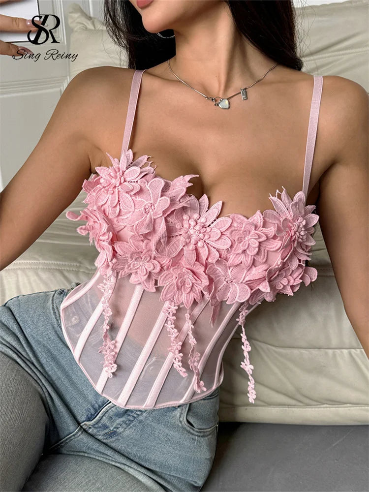 Pink sheer gauze corset top featuring 3D embroidered floral appliques, thin straps, and boning details.