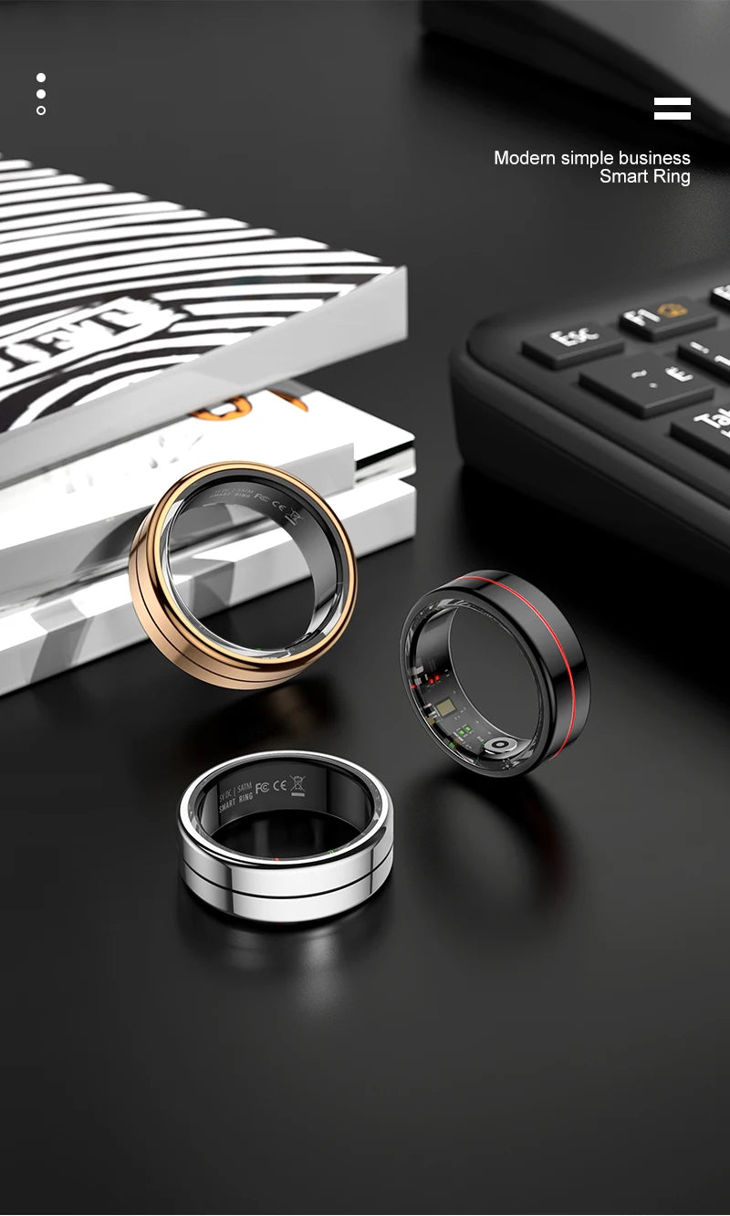 Three modern smart health tracking rings in gold, silver, and black on a desk, featuring internal fitness sensors.