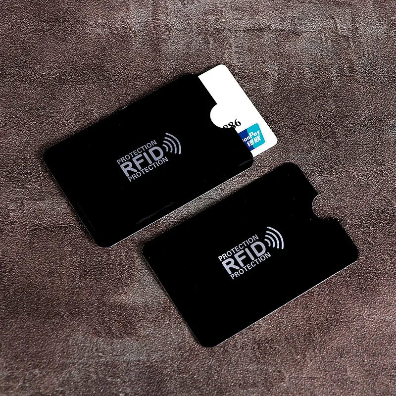 Two black plastic RFID blocking sleeves for credit cards, featuring white printed icons and text.