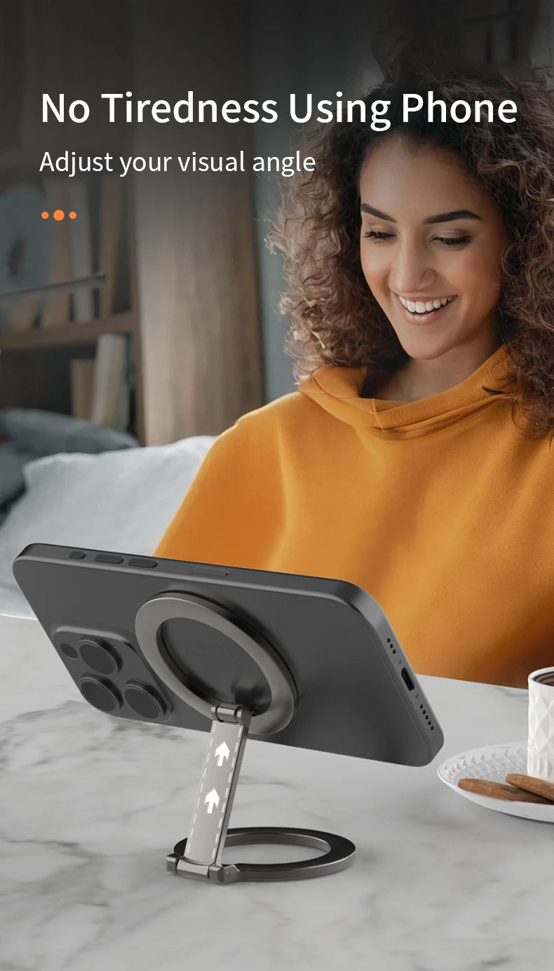 A sleek, dark grey adjustable metal phone ring stand attached to the back of a smartphone on a marble tabletop.