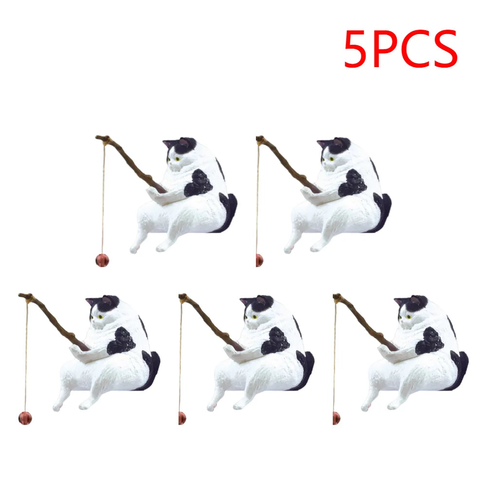 A set of five miniature black and white cat ornaments, each sitting and holding a rustic fishing rod.