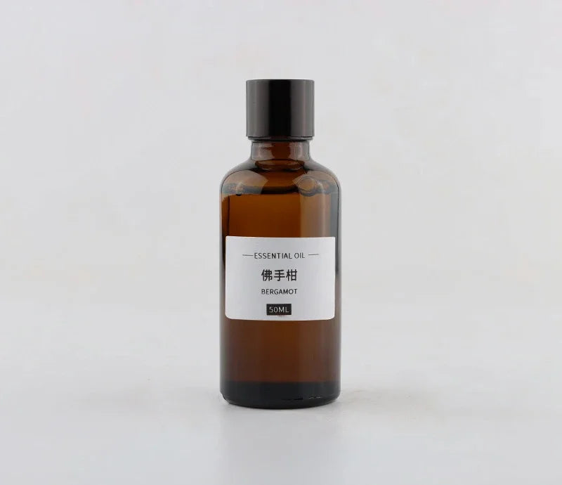 Amber glass 50ml bottle of Bergamot essential oil with a minimalist white label and black cap.