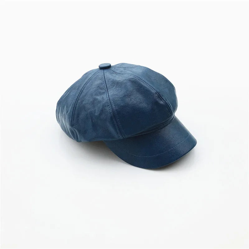 Blue faux leather baker boy cap with a panelled design and short peak.