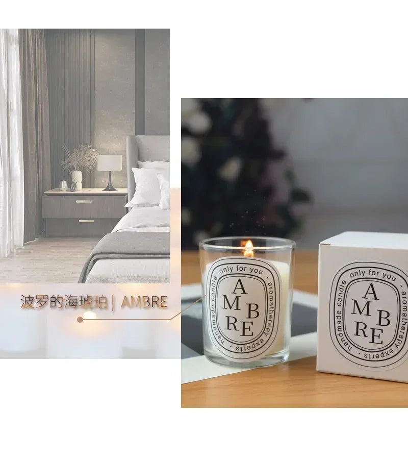 Lit amber-scented aromatherapy candle in a clear glass jar with a minimalist oval label, next to its matching box.