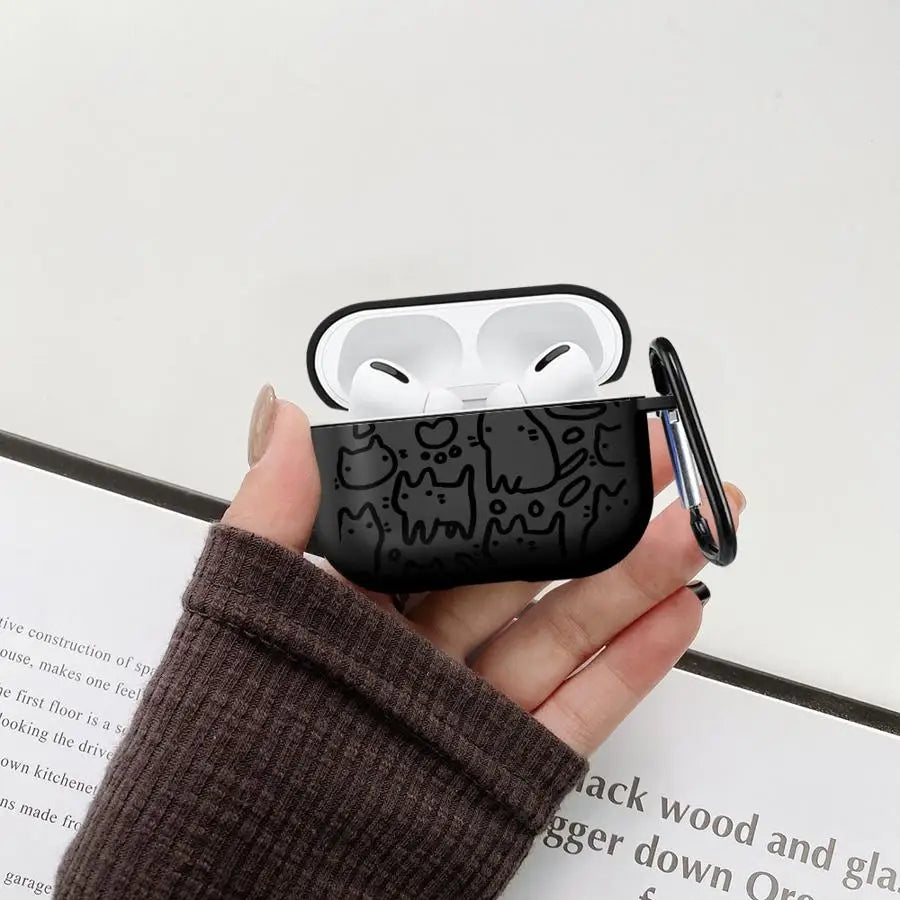 Black silicone AirPods Pro case featuring a cute cat doodle print and a metal carabiner clip.