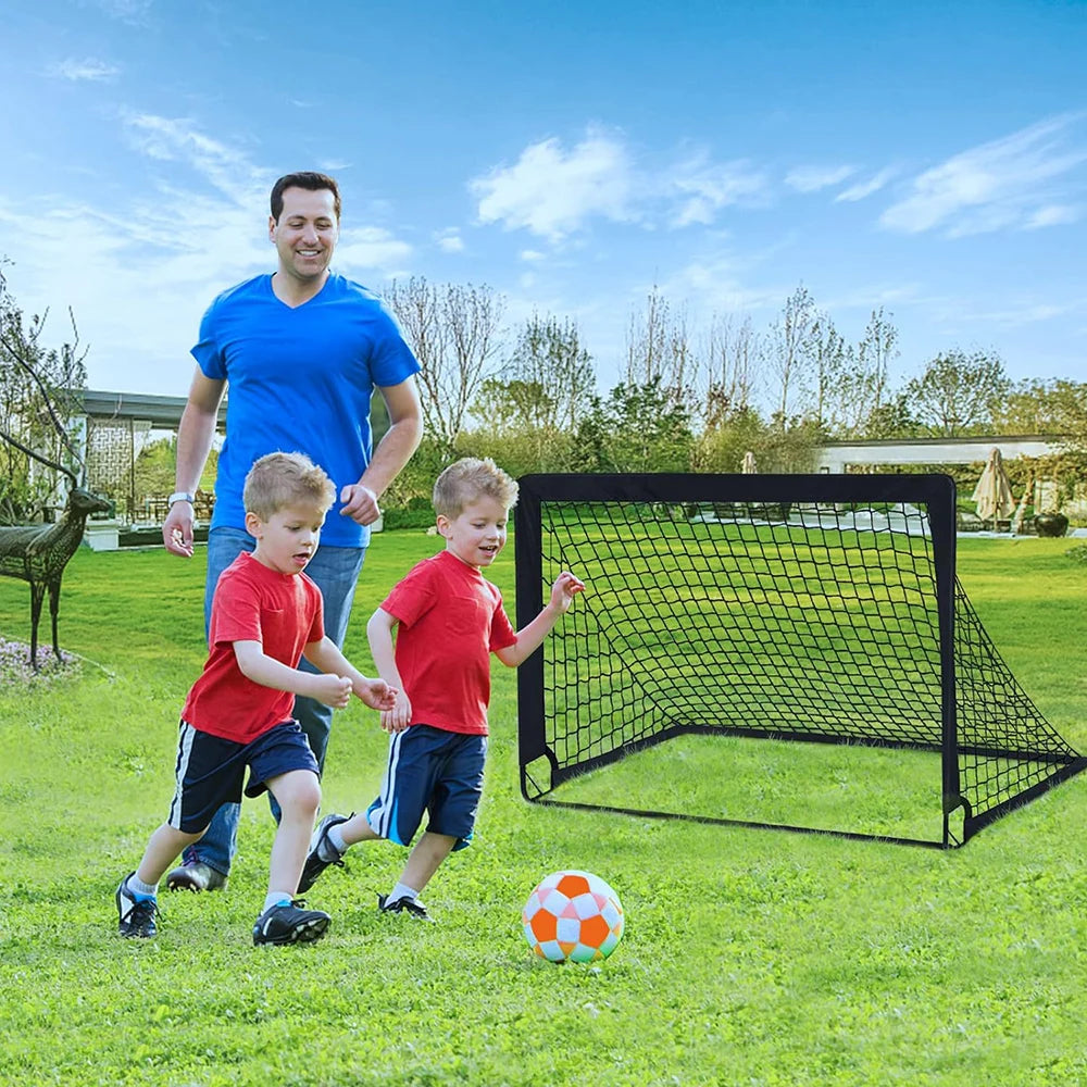 A father and two children playing football in a garden next to a portable, black rectangular football goal net.