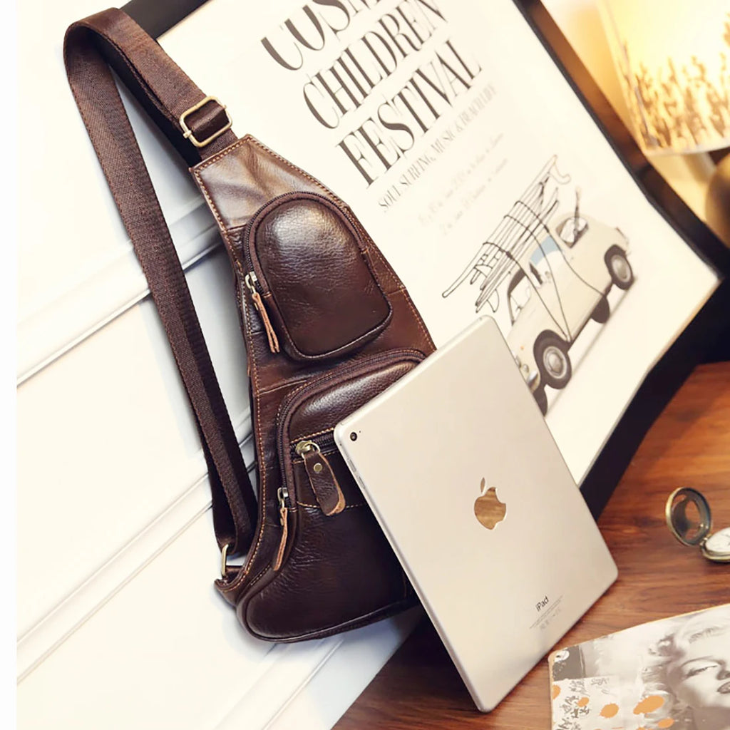 Dark brown leather crossbody sling bag with adjustable strap, zip compartments, and sleek, compact design.