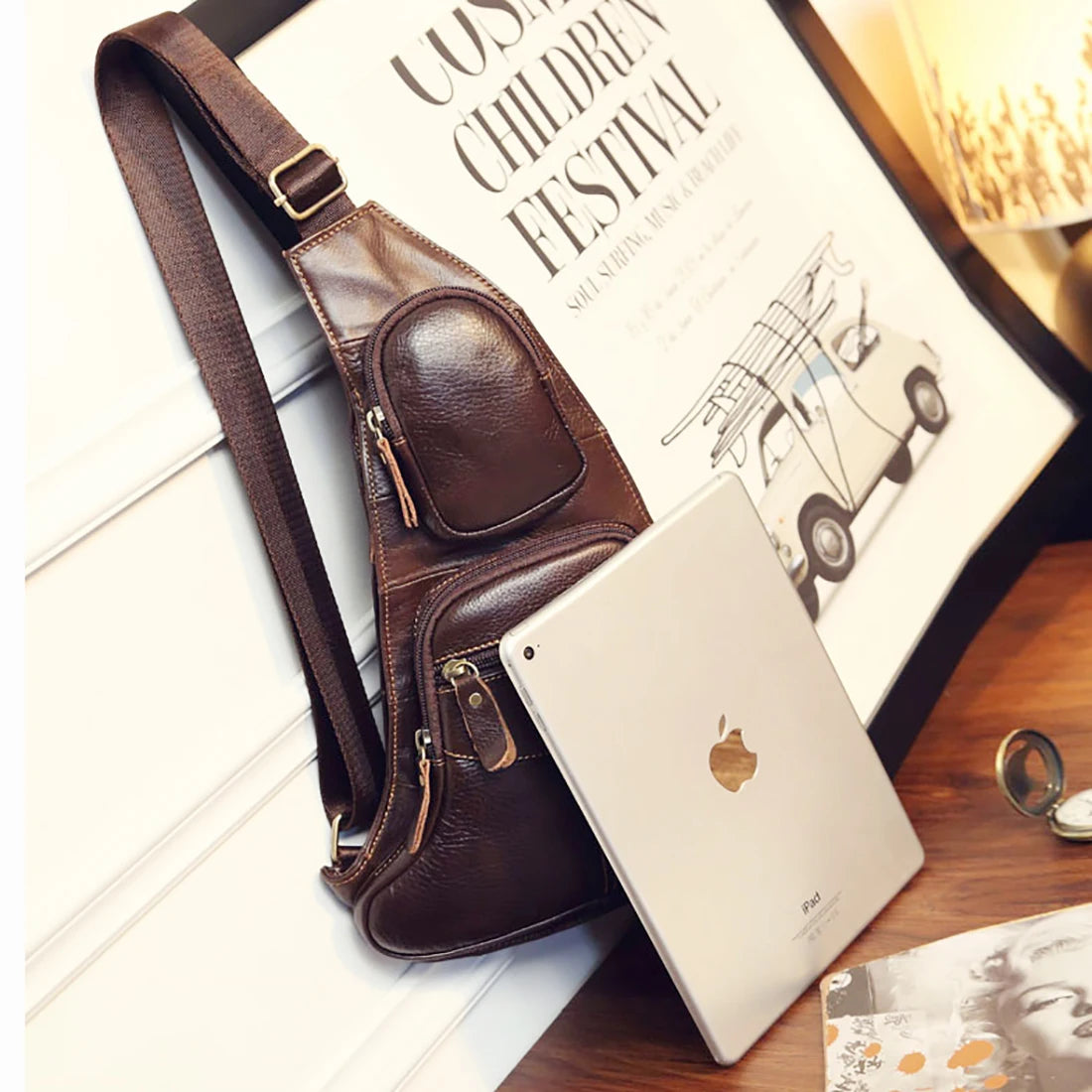 Dark brown leather crossbody sling bag with adjustable strap, zip compartments, and sleek, compact design.