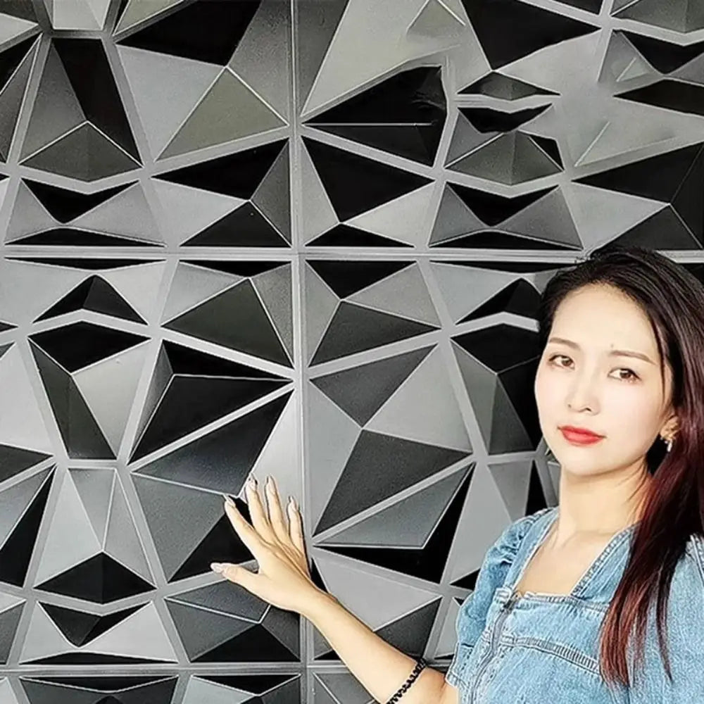 A person touching modern, black 3D diamond-patterned decorative wall tiles with a sleek, angular geometric design.