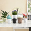 A group of modern, spiral-textured plastic flower pots in various colors displayed on a white table.