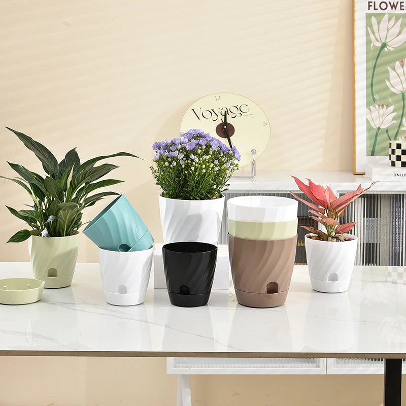 A group of modern, spiral-textured plastic flower pots in various colors displayed on a white table.