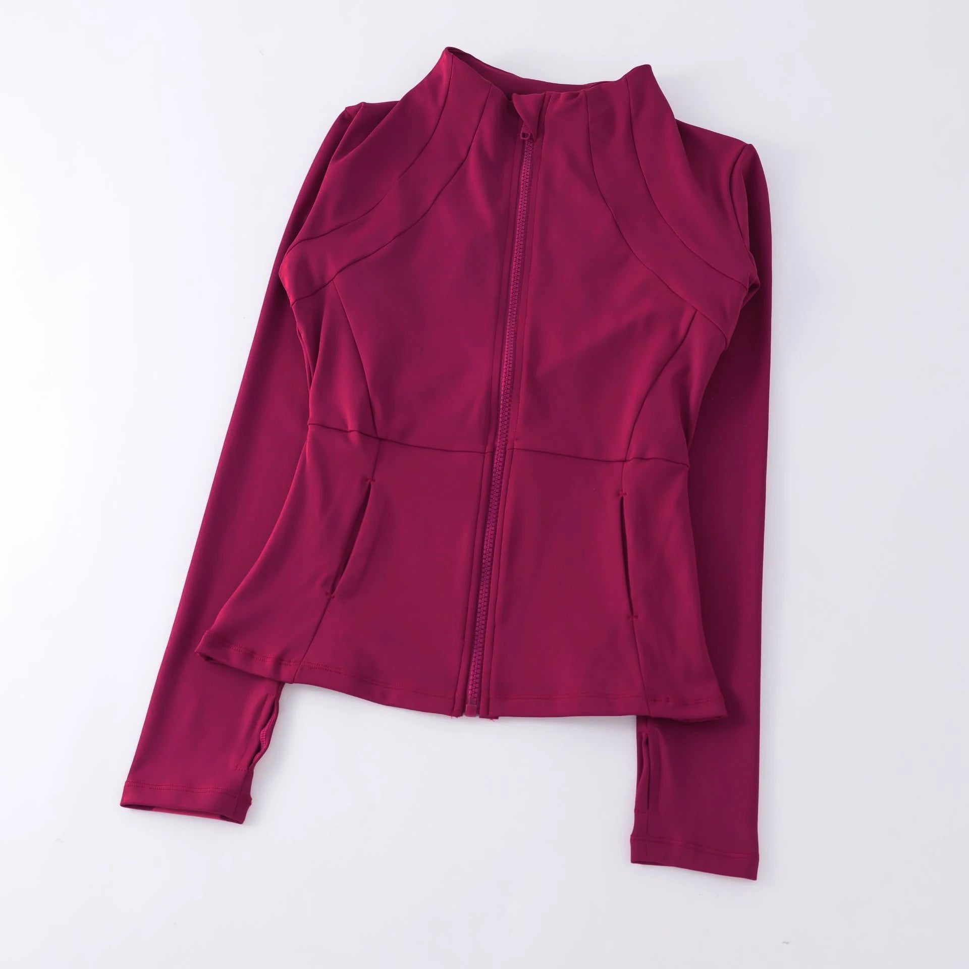 Deep pink athletic zip-up jacket with a mock neck, fitted silhouette, and thumbhole sleeves.
