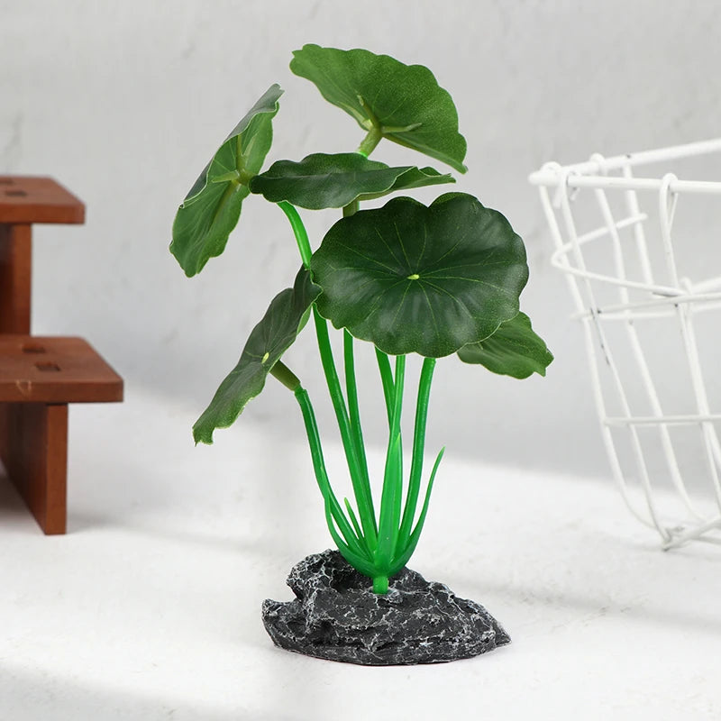Artificial aquarium plant with round green lily-pad leaves on bright green stems anchored by a textured gray rock base.