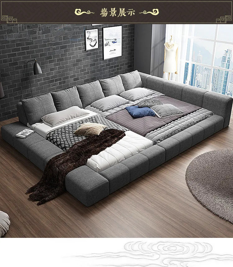 Modern grey fabric double bed with a wide padded frame and integrated headboard cushions.