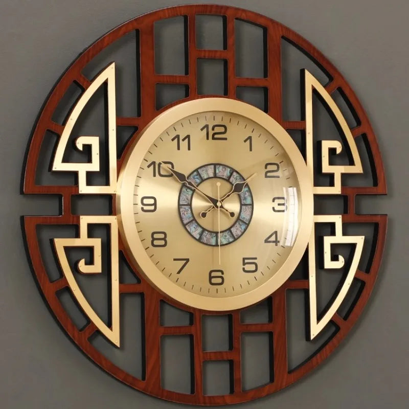 Circular wall clock with a dark wood-effect geometric frame, gold face, and central mother-of-pearl inlay detail.