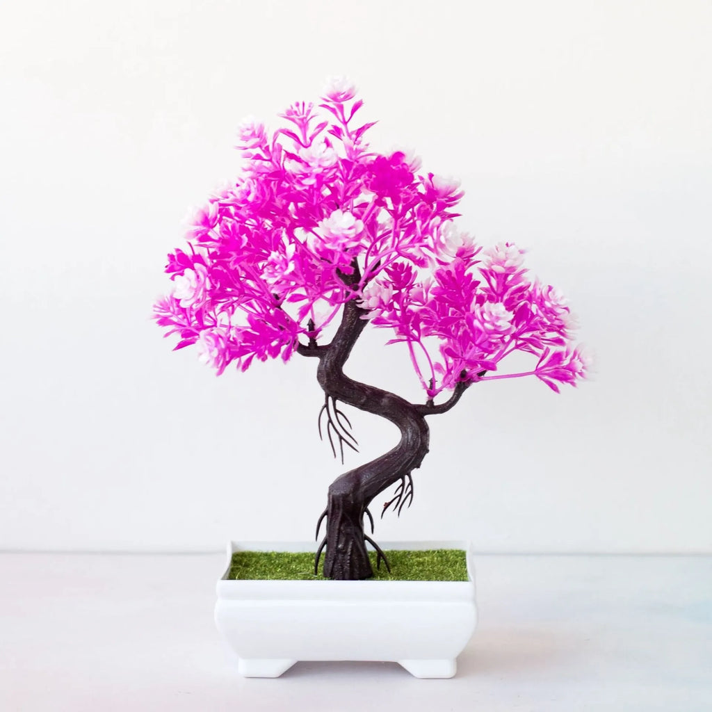 Artificial bonsai tree with vibrant pink and white leaves in a small rectangular white pot on a plain white background.