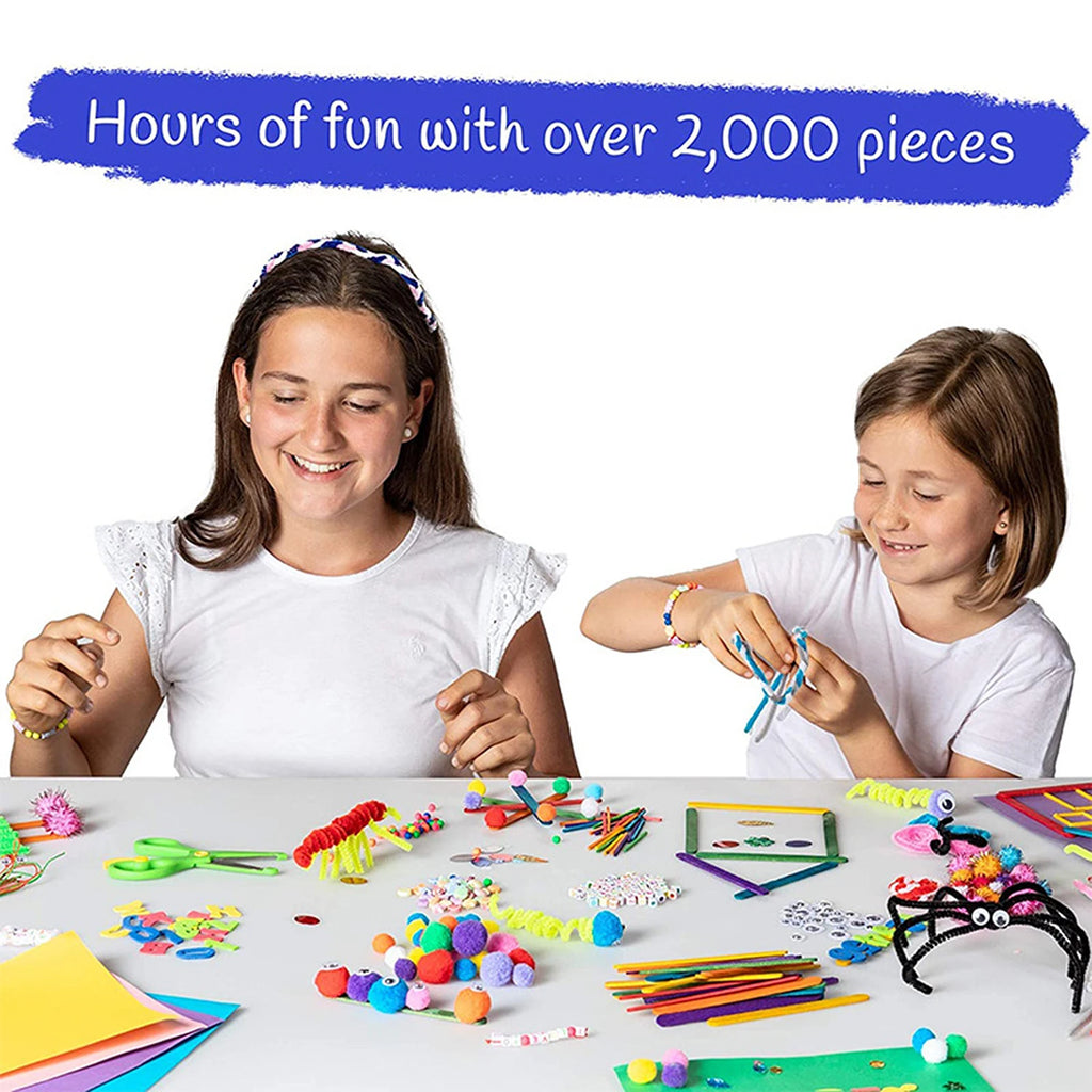 Two girls smiling while crafting with a multi-coloured 2,000-piece arts and crafts set on a white table.