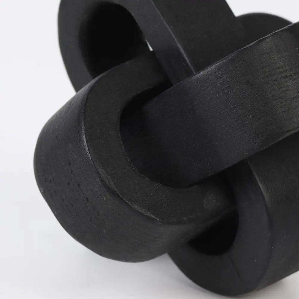 Decorative matte black wooden chain link knot ornament, featuring interlocking rounded loops with a textured finish.