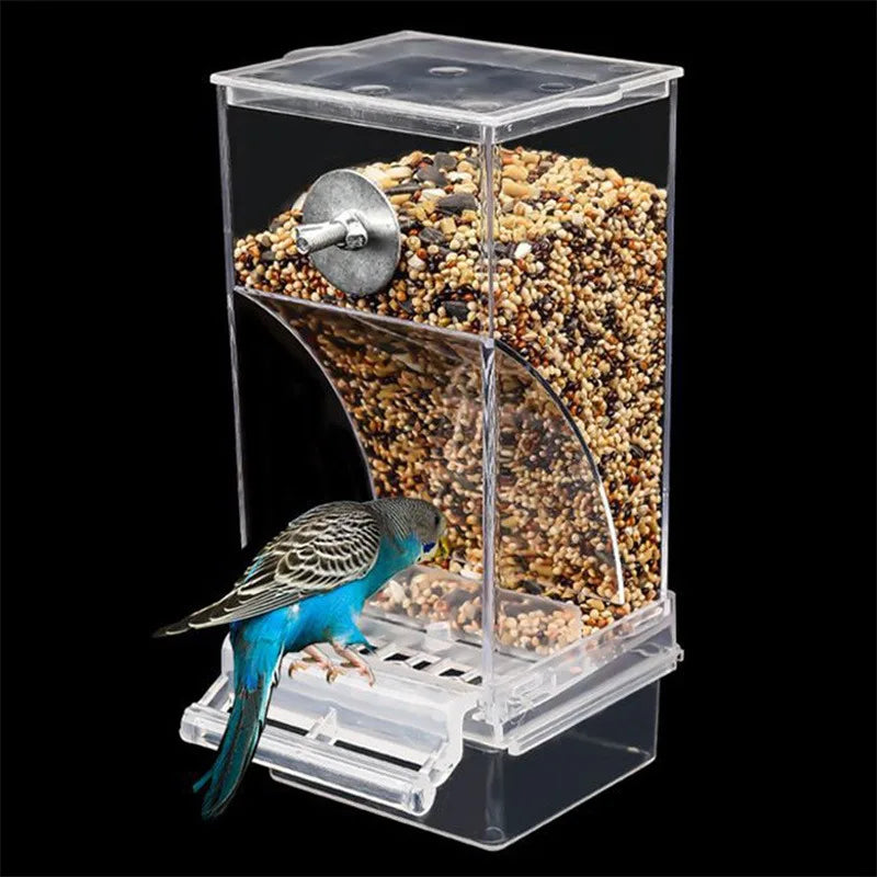 Clear acrylic automatic bird feeder filled with seeds, with a blue parakeet eating from the tray.