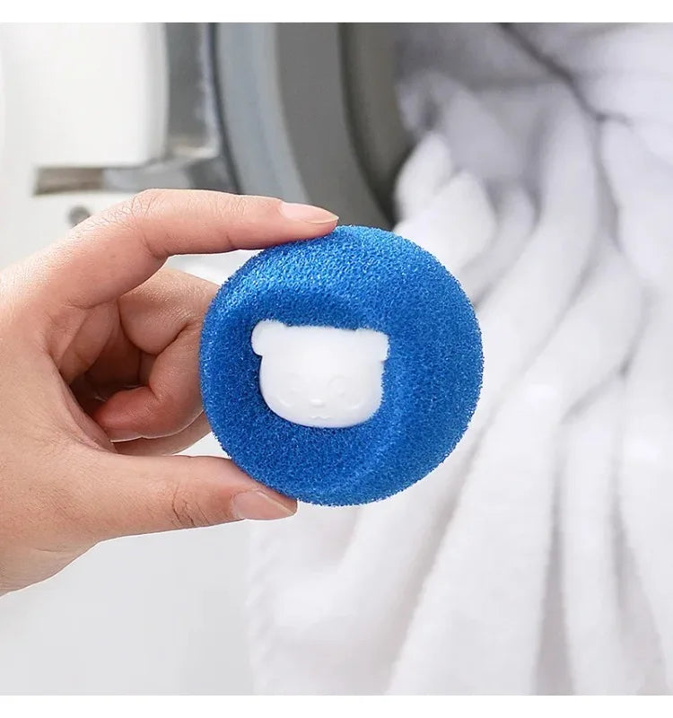 Hand holding a blue, textured laundry ball with a cute white bear face in the centre.