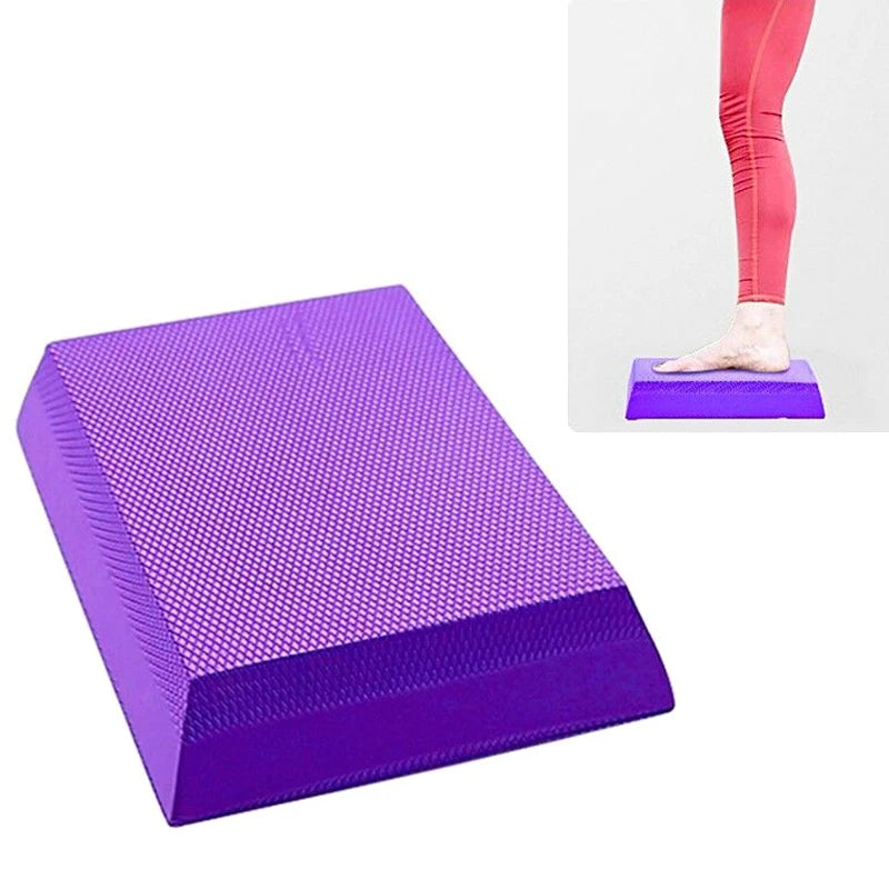 A purple, rectangular TPE foam balance pad with a textured, non-slip surface, shown in use by a person in leggings.
