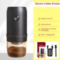 Matte black portable electric coffee grinder with a clear base, grind adjustment dial, charging cable, and brush.