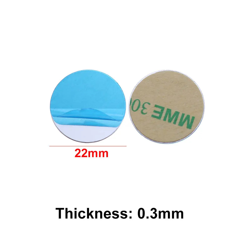 Two circular 22mm adhesive metal discs, one showing a blue backing film and the other the tan adhesive side.