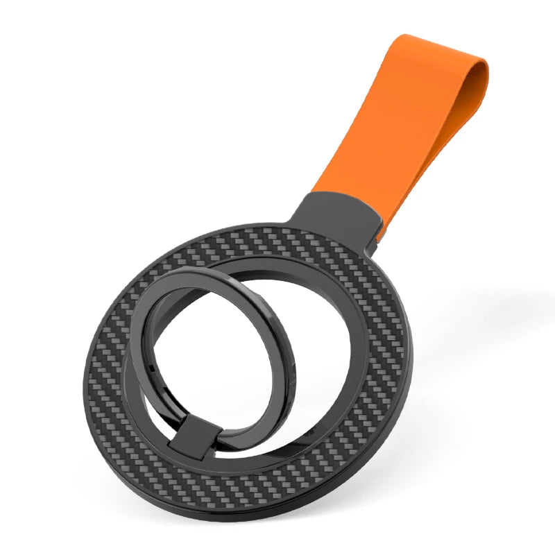 A black carbon fiber patterned circular phone ring holder with an orange loop strap on a white background.