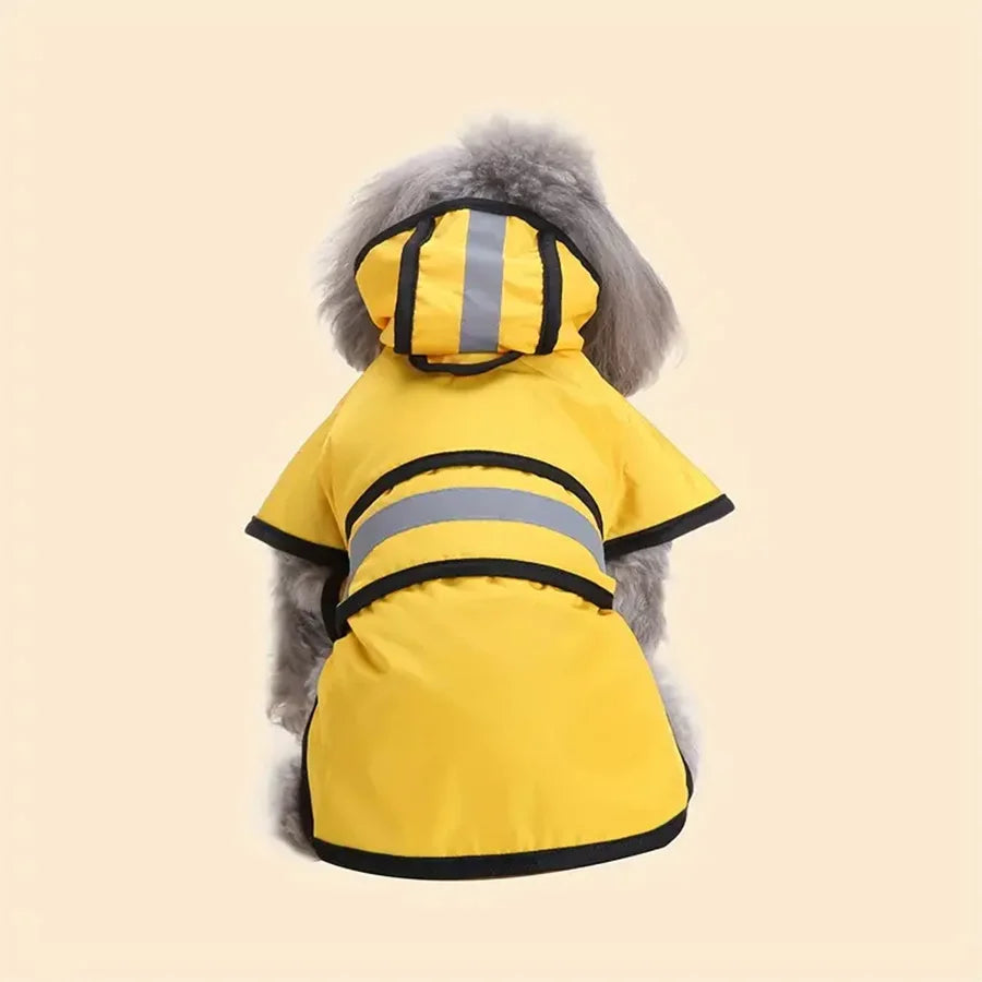 A fluffy dog wearing a bright yellow, hooded waterproof raincoat with black trim and reflective safety strips.