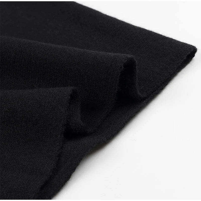 Black knitted shawl jumper with soft, draped fabric in a loose, elegant cape style.