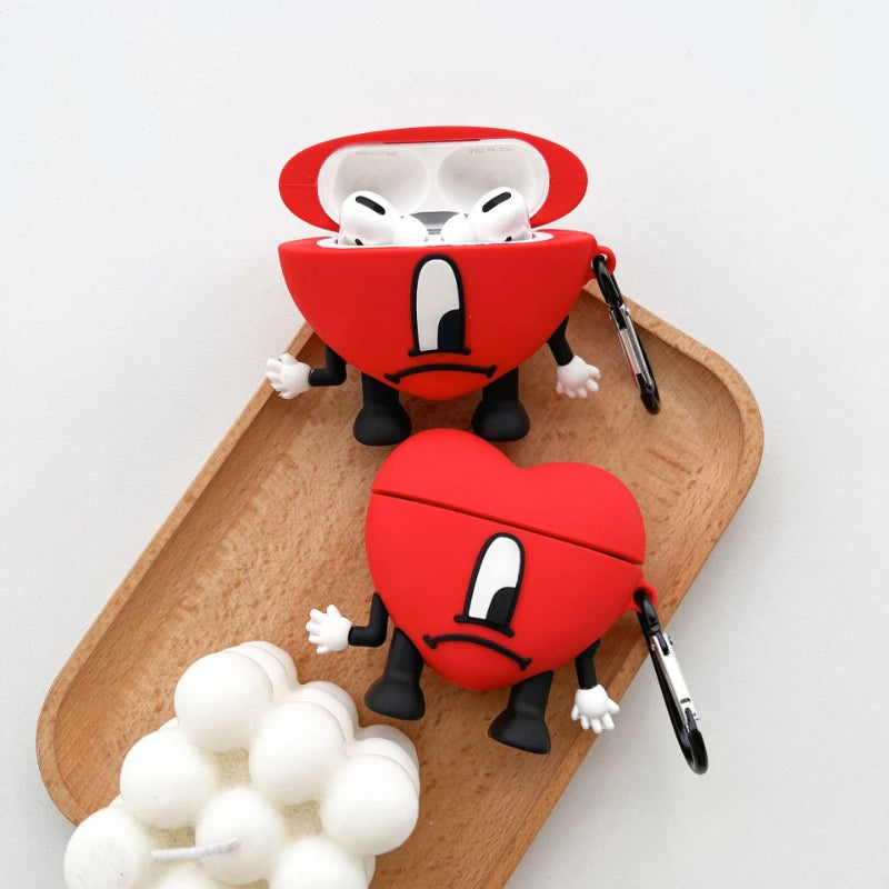 Red silicone AirPods Pro case featuring the Bad Bunny heart character with arms and legs, plus a metal carabiner.