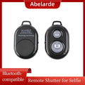 Black plastic Bluetooth remote shutter for smartphones with Android and iOS camera buttons.