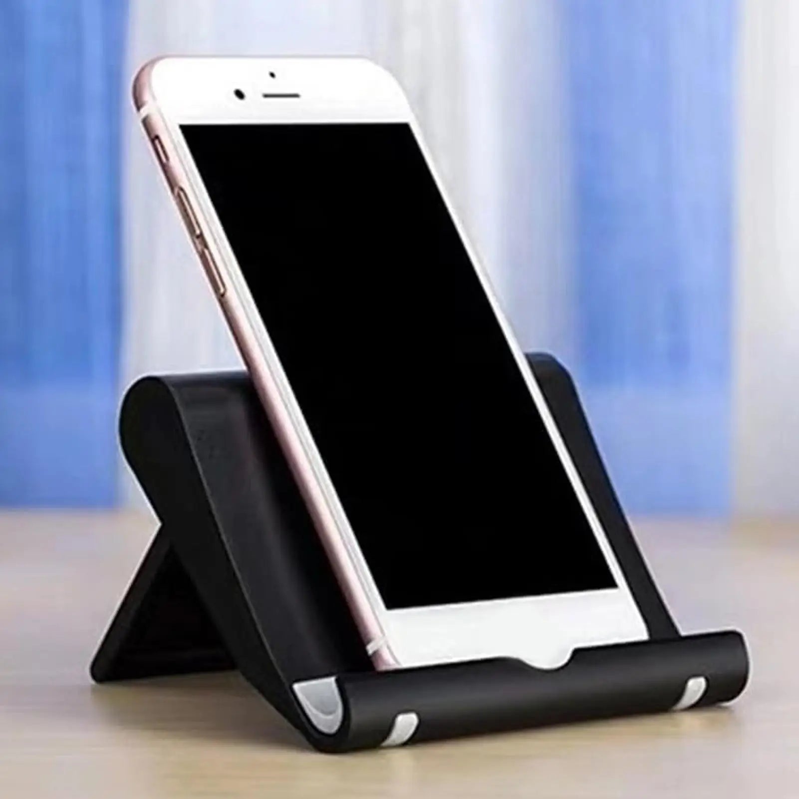 A white smartphone resting in an adjustable, black ergonomic mobile phone stand on a desk surface.