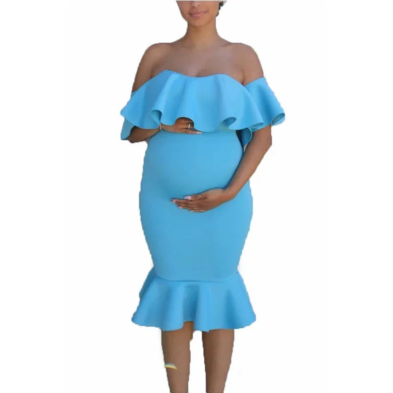 Bright blue maternity midi dress with off-the-shoulder ruffled neckline and flared mermaid hem.