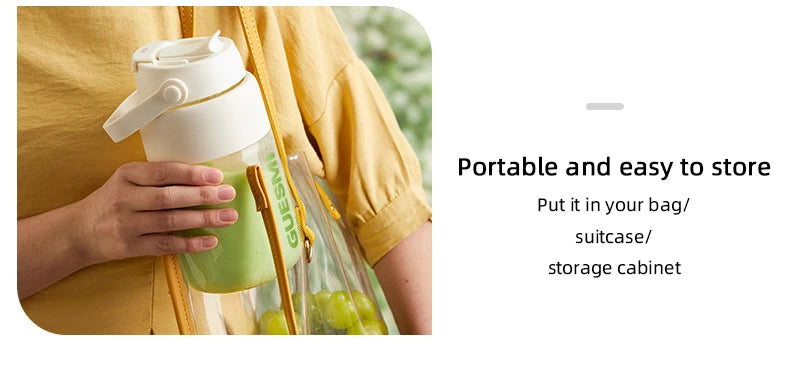 A person holds a portable clear water bottle with a white lid and handle containing a green drink.